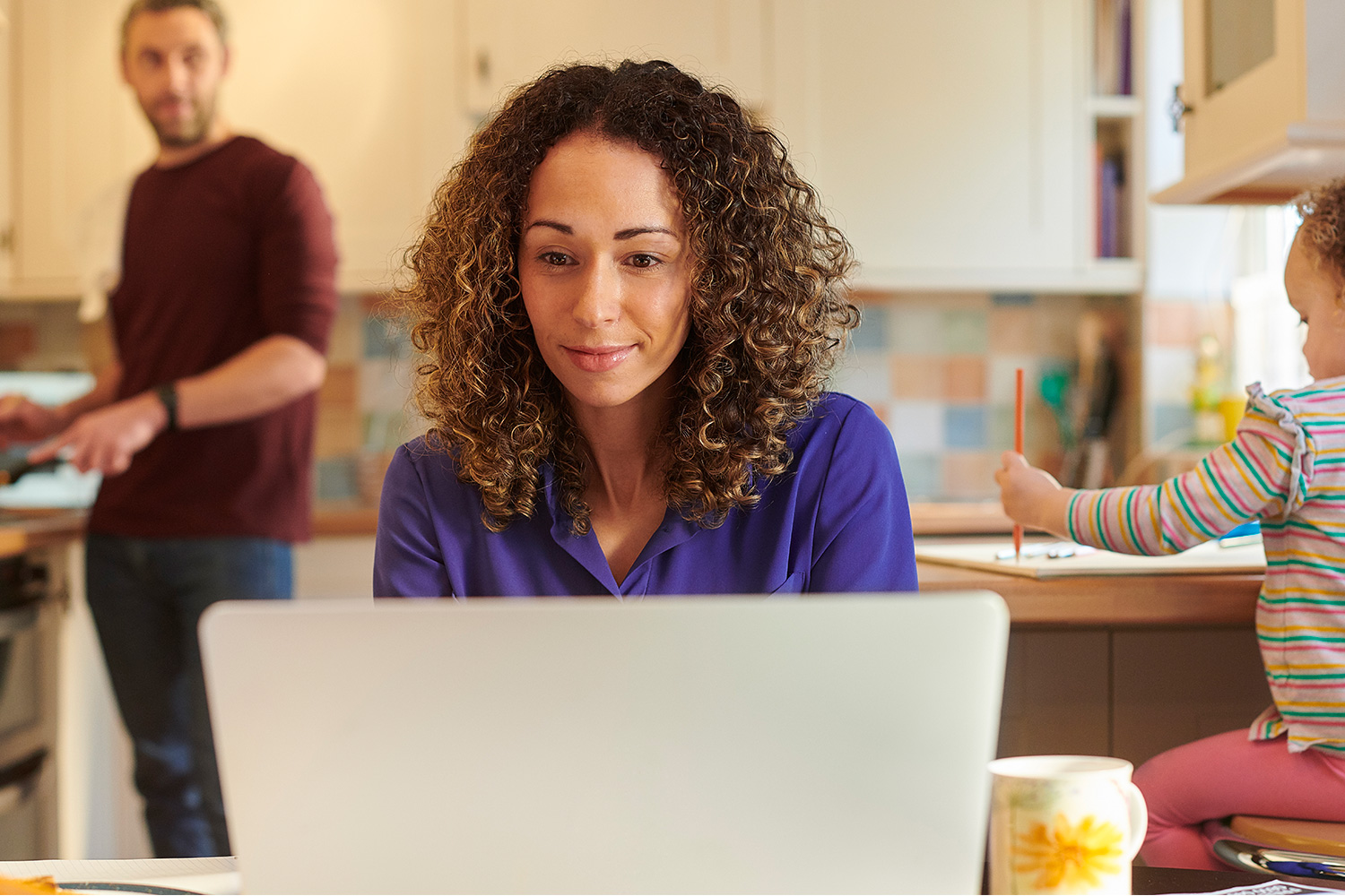 Adult learner studying at home with her family.