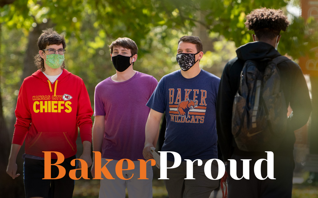 Male students walking across campus wearing masks. Baker Proud alumni magazine title across the bottom of the photo.