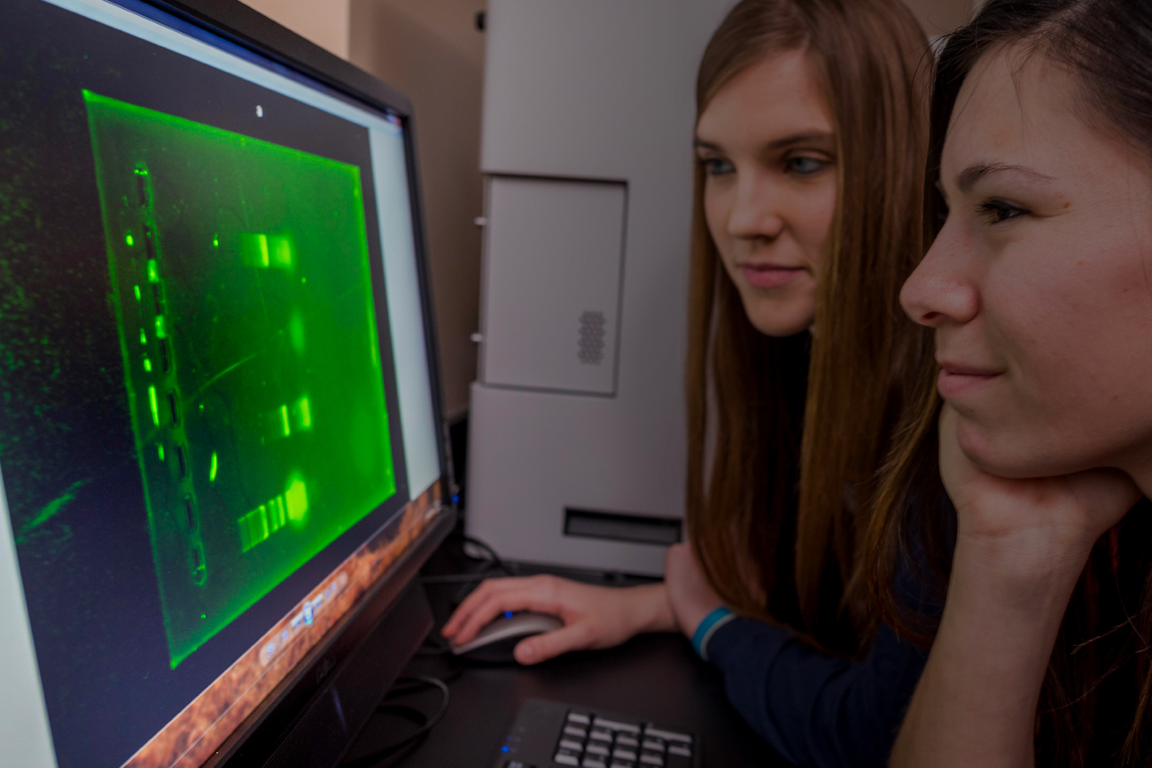 Two students at a computer working on a project.