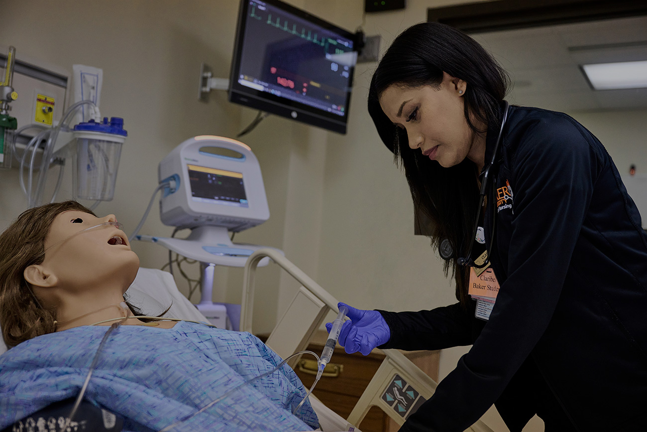 Nursing student learning about medical equipment through the simulation lab.