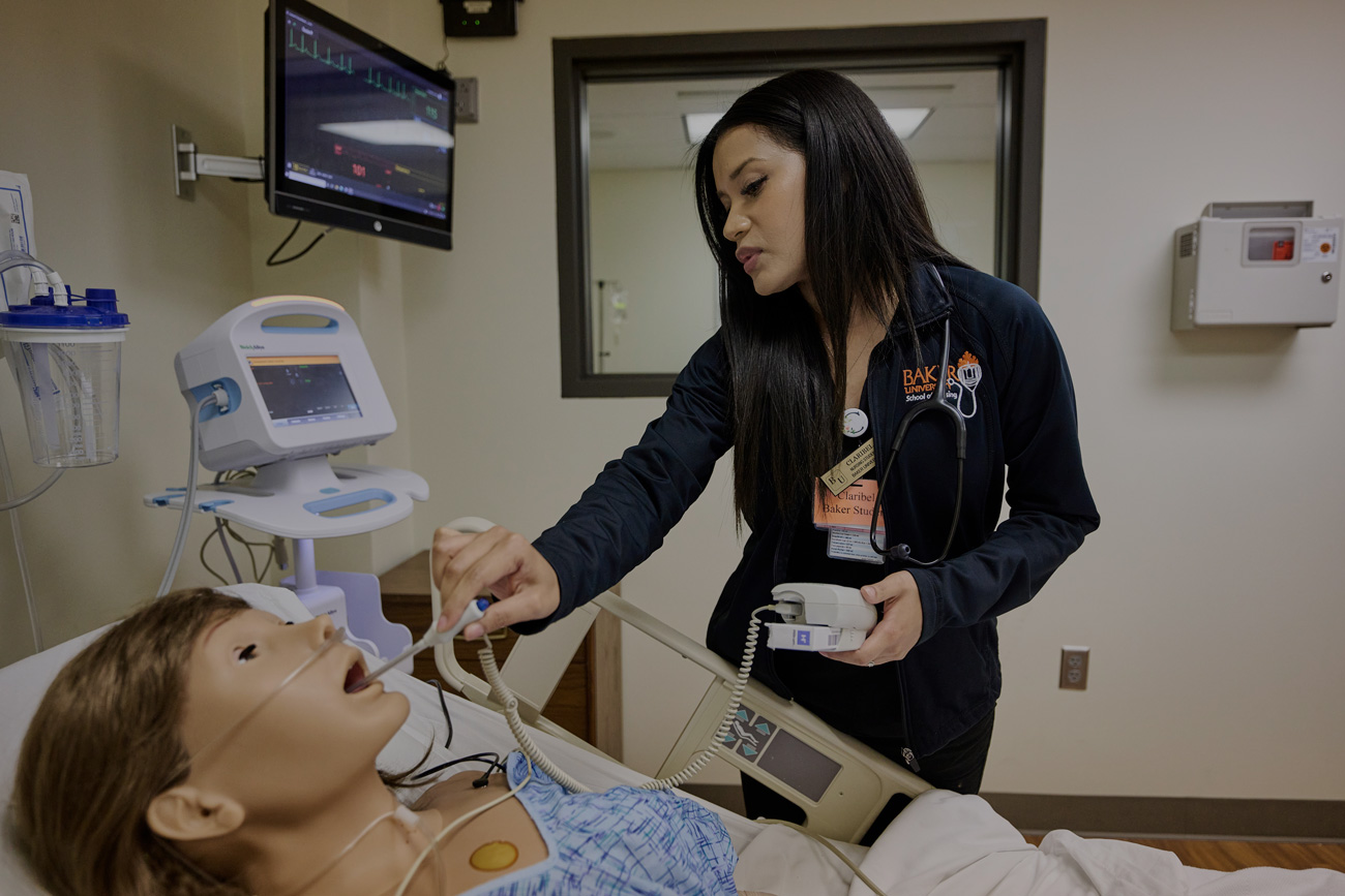 Nursing student learning about medical equipment through the simulation lab.