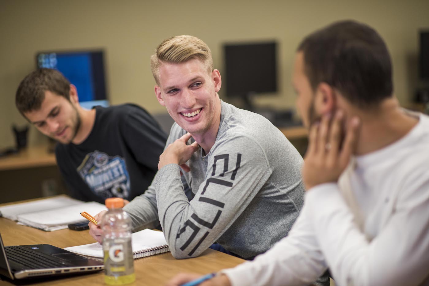 Male students discussing during class