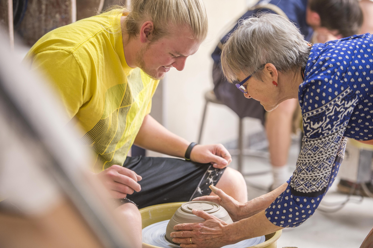 Professor Inge Balch working with male student in ceramics class
