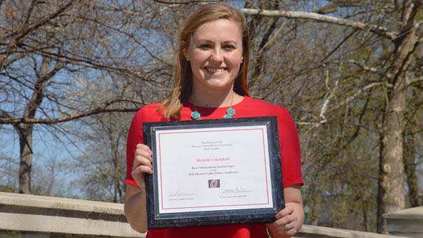 Student holding award