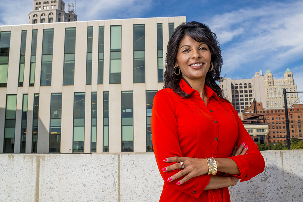 Kansas City business woman posing with arms crossed and smiling in front of office building