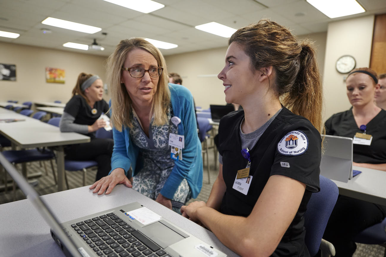 Nursing student talks with professor