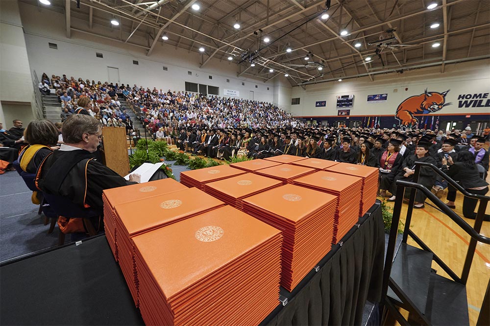 Graduates and supporters in Collins gym at graduation