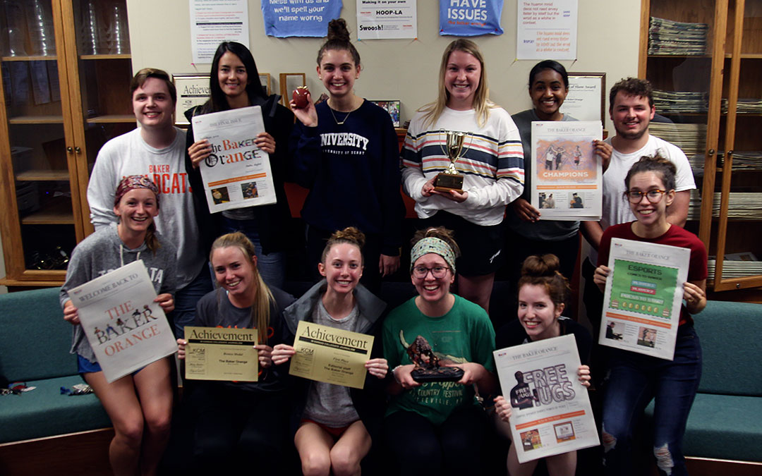 Baker orange students staff holding copies of the newspapers and award