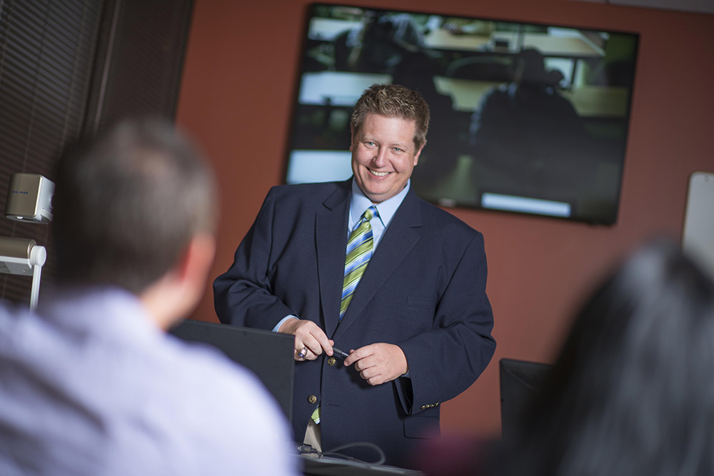 Professional businessman smiling at a student during class