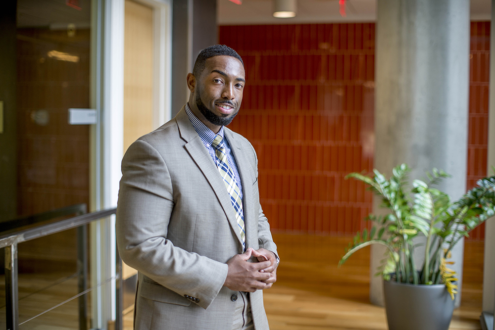 Student in a suit smiling and posing for a professional photo