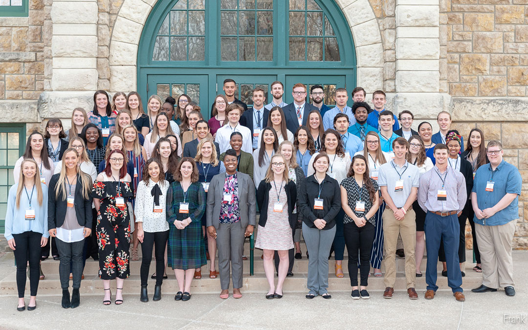 Dialogos student presenters standing in front of Mabee Hall