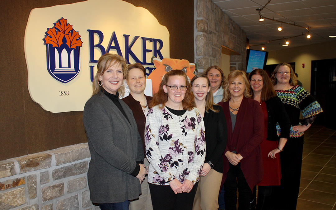 Group photo of doctoral educators in front of Baker University logo