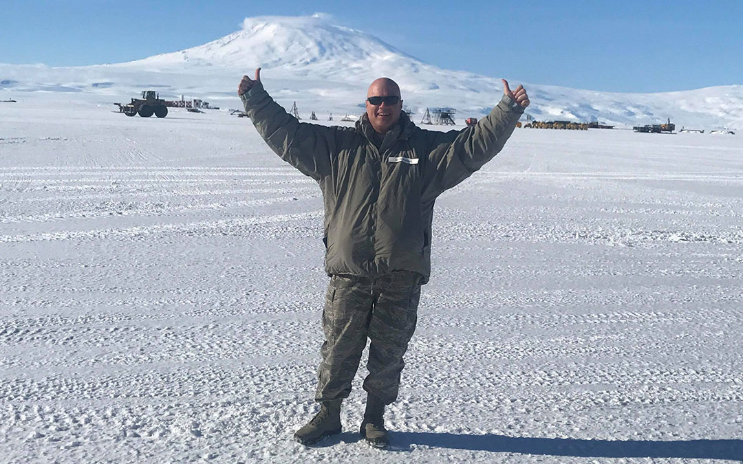 Kevin Hopkins in Antartica smiling with two thumbs up