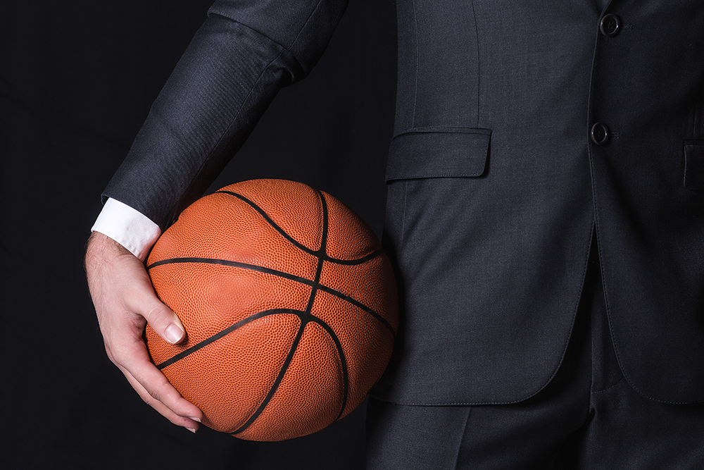 Close up of basketball held by a person in a suit