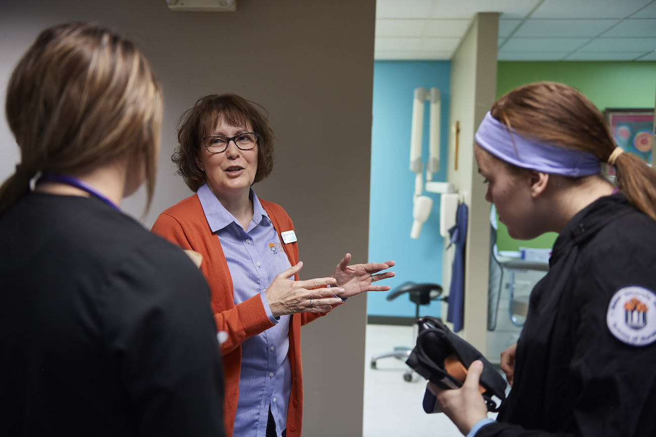 Nursing instructor talking with two students in the hall