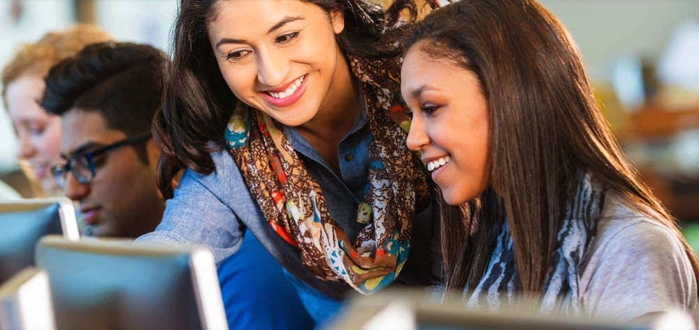 Teacher working with students at a computer