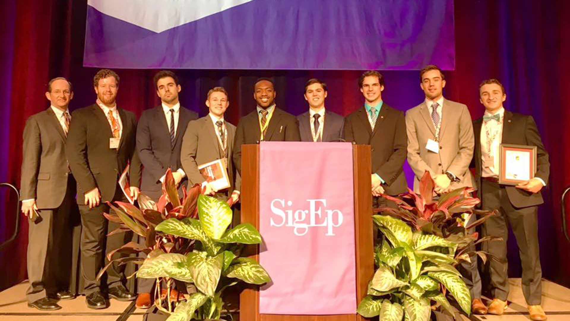 Sigma Phi Epsilon fraternity members standing on stage together after winning award