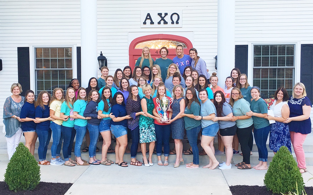 Group photo of Alpha Chi Omega ladies receiving National Council Trophy