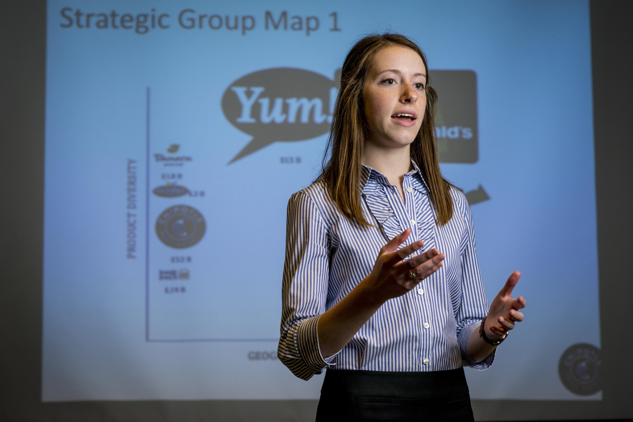 Business student giving a presentation in front of a screen