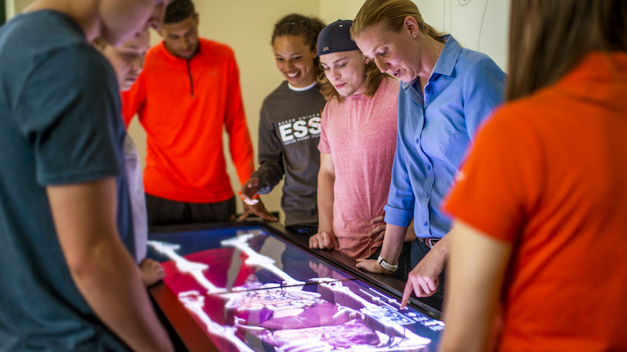 Professor Erin Holt working the classroom with students on anatomage table