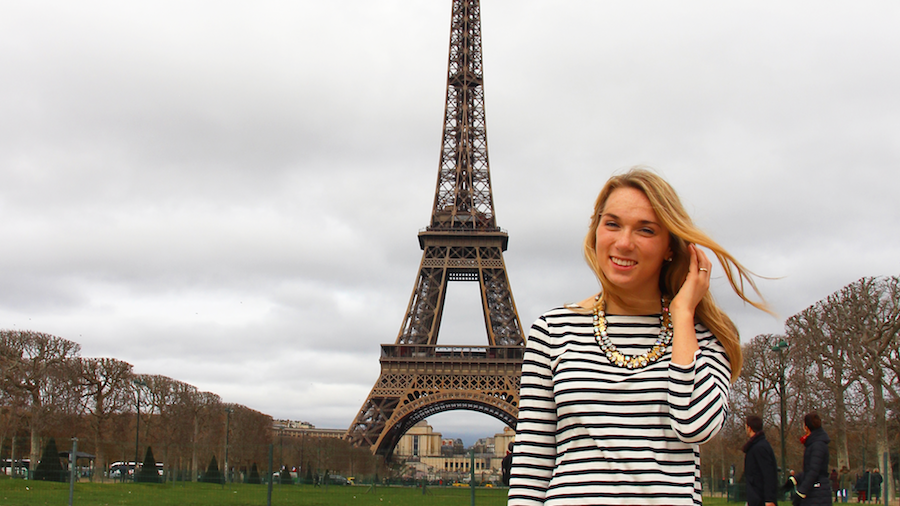 Study abroad student posing in front of the Eiffel Tower