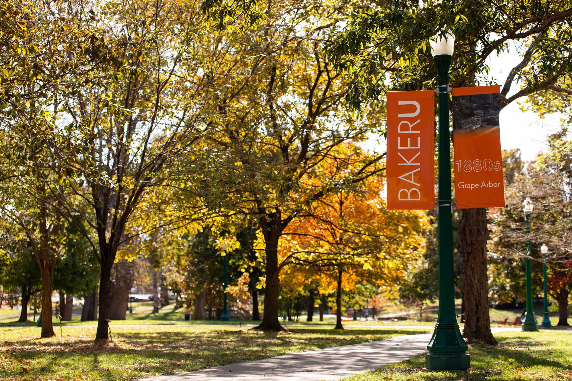 Baldwin City campus with trees and Baker U banner for the Grape Arbor 1880s.