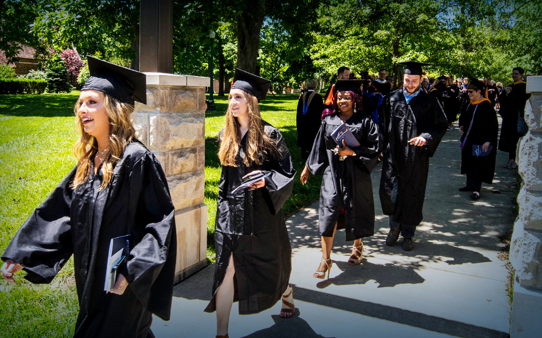 Baker students marching across campus during commencement