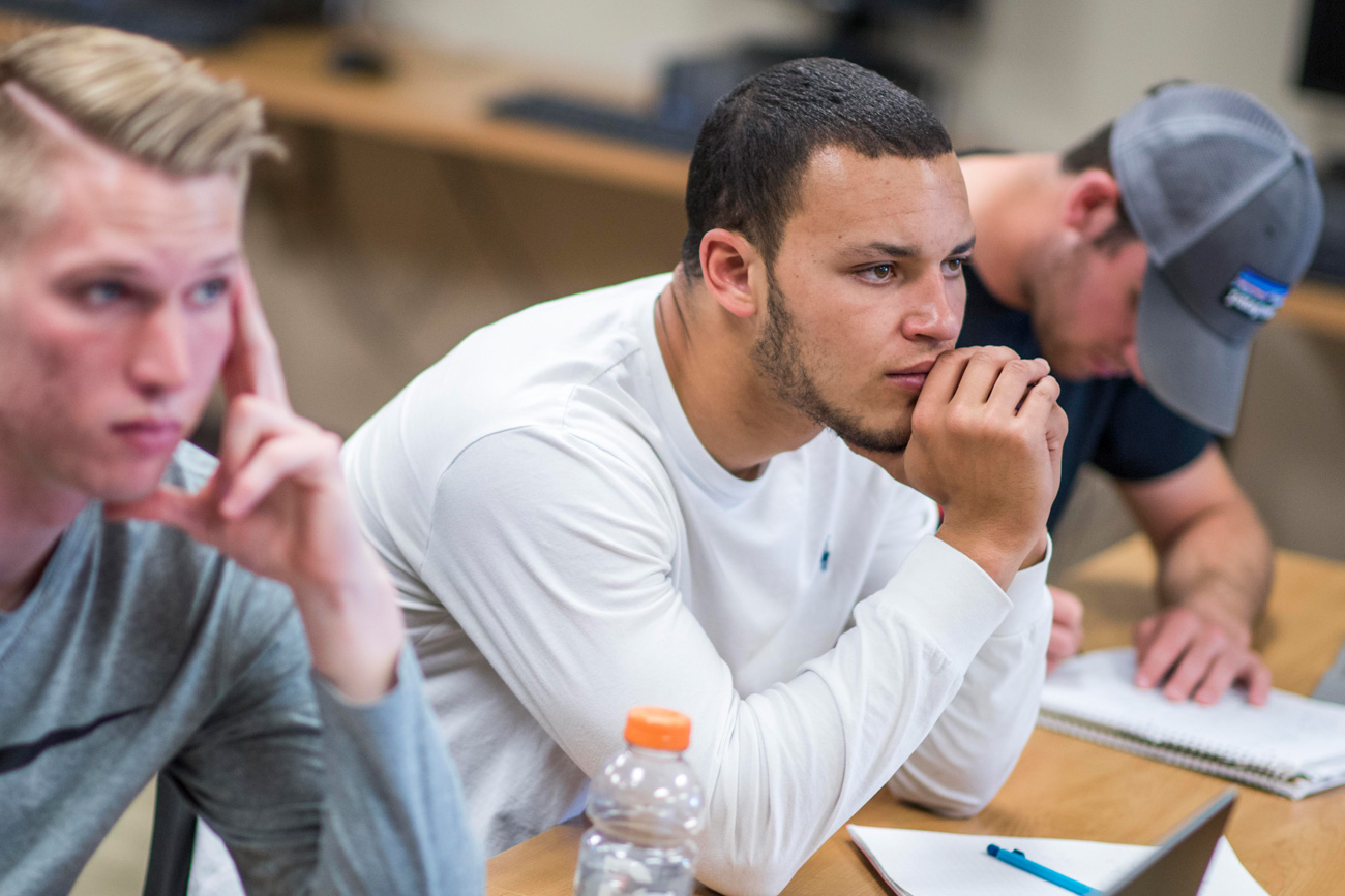 Male students sitting in classroom looking focused