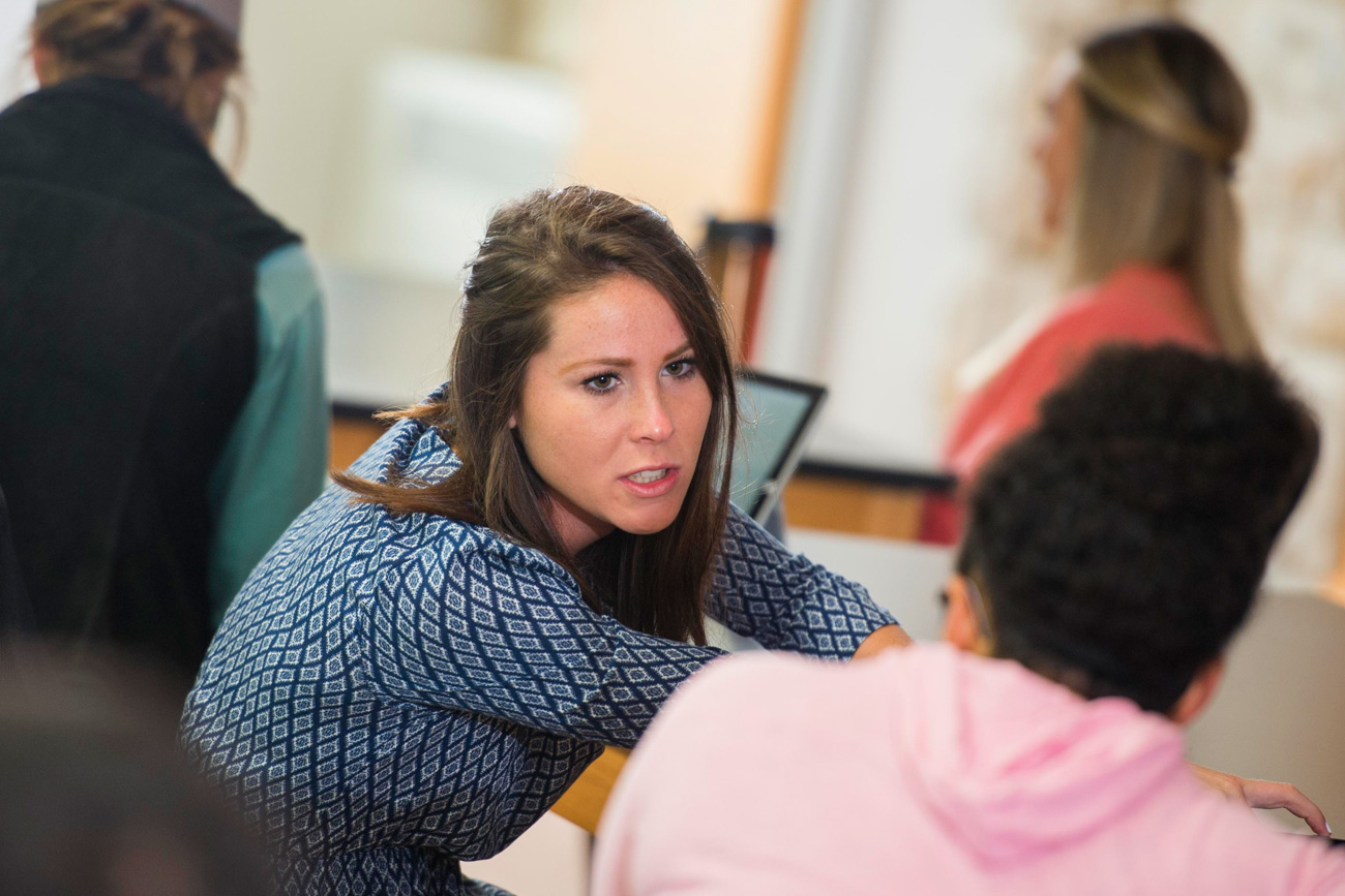 Two female students talking in a classroom