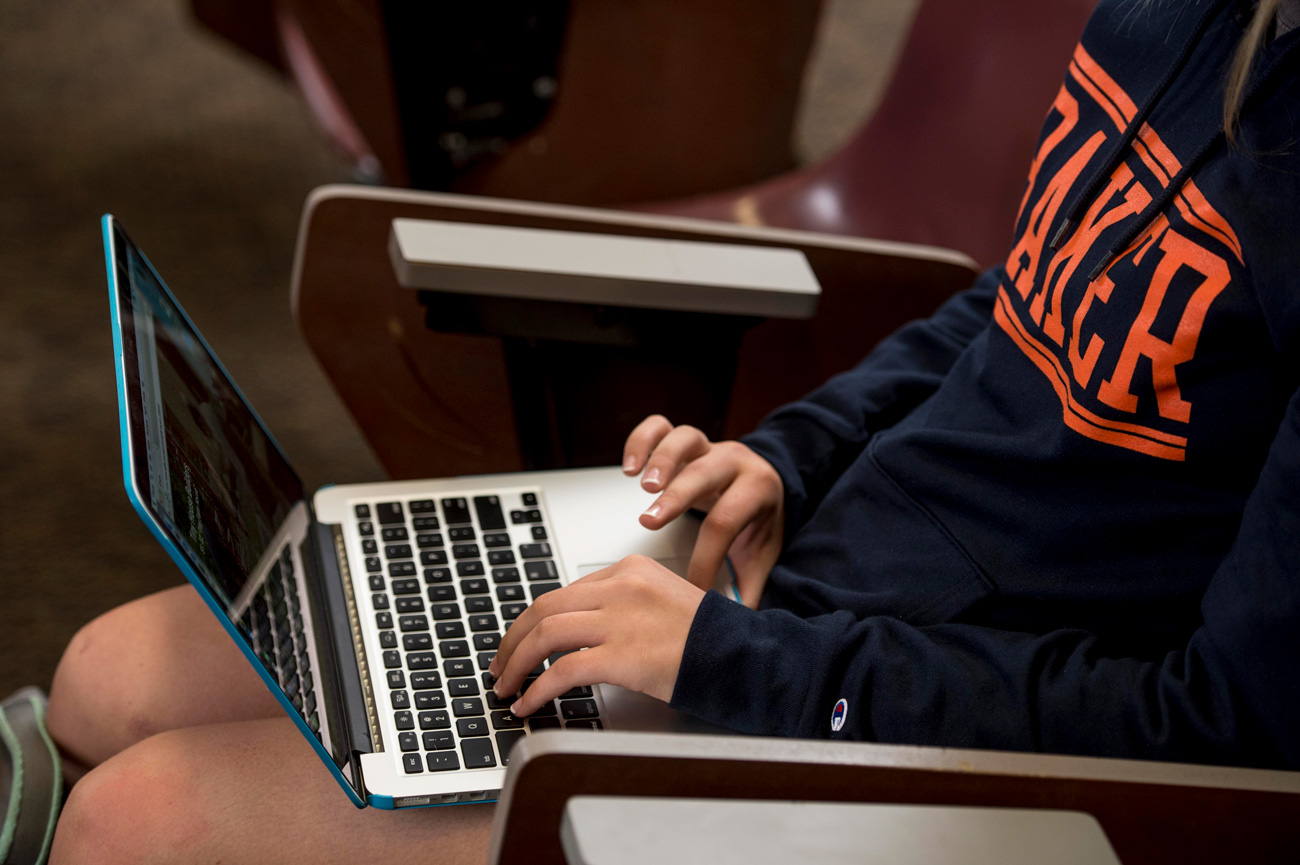 Female student in classroom working on her laptop