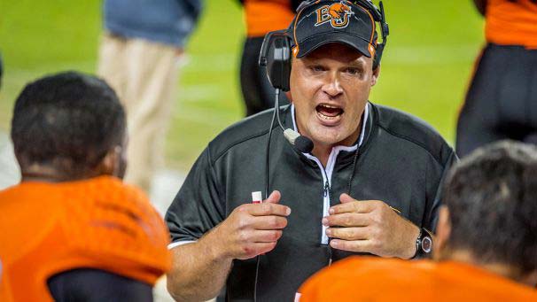 Football coach talking to football players at a game