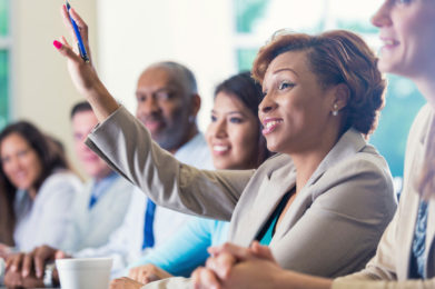 administrator in a meeting raising hand