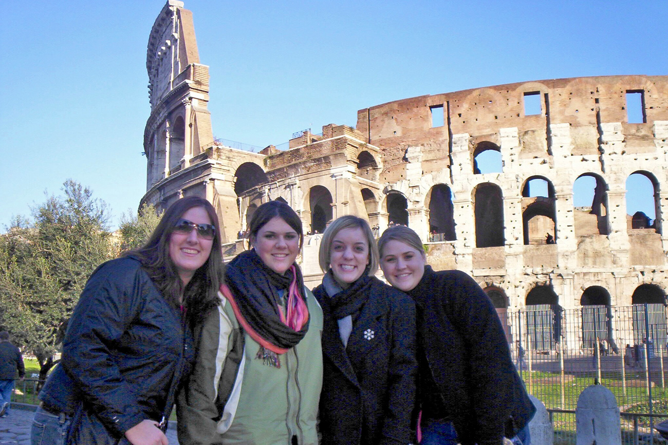 Students posing in front of the colosseum in Italy while studying abroad