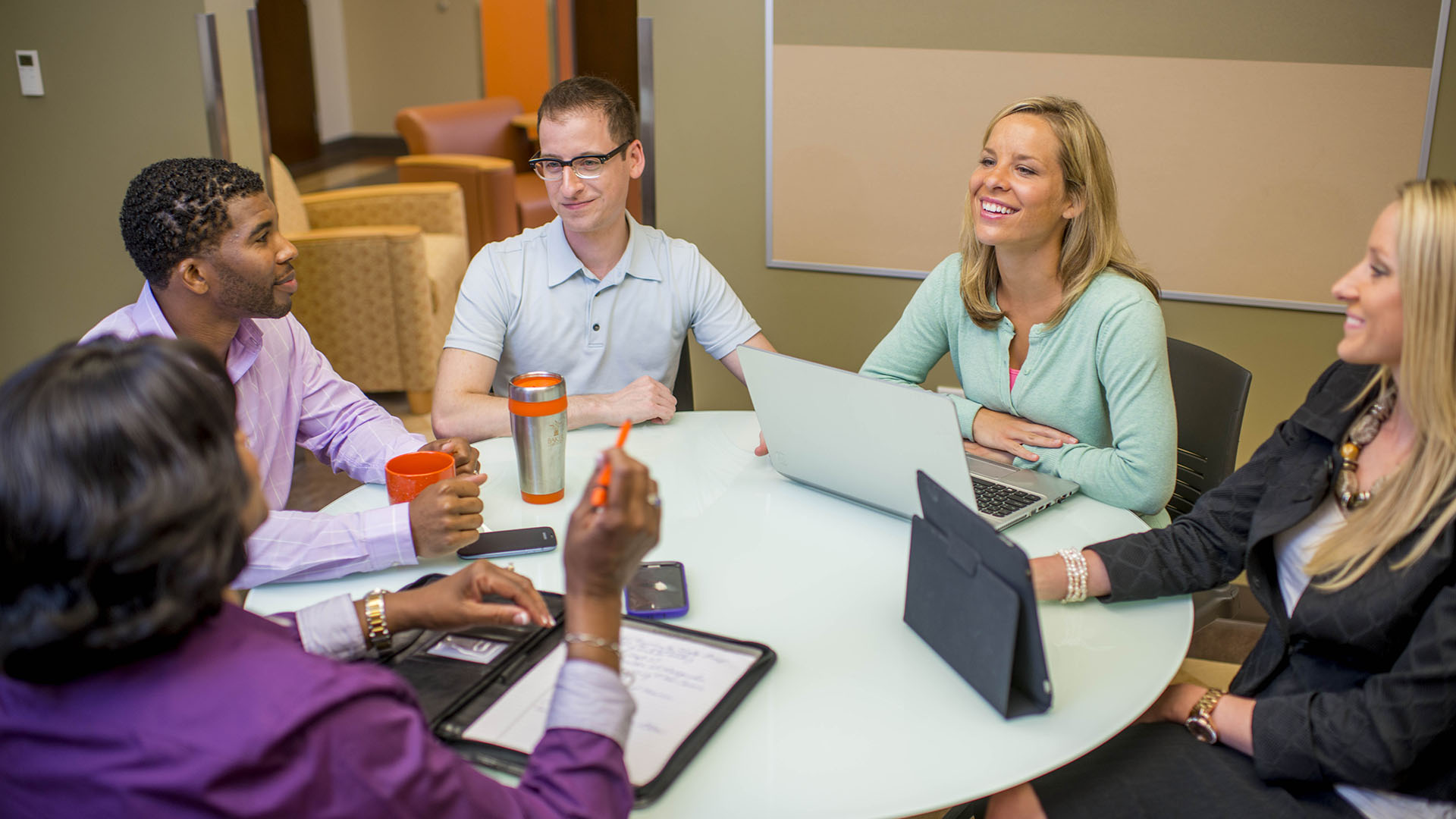 Students siting around table discussing coursework