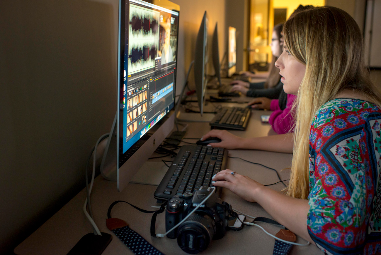 Female student editing video on computer