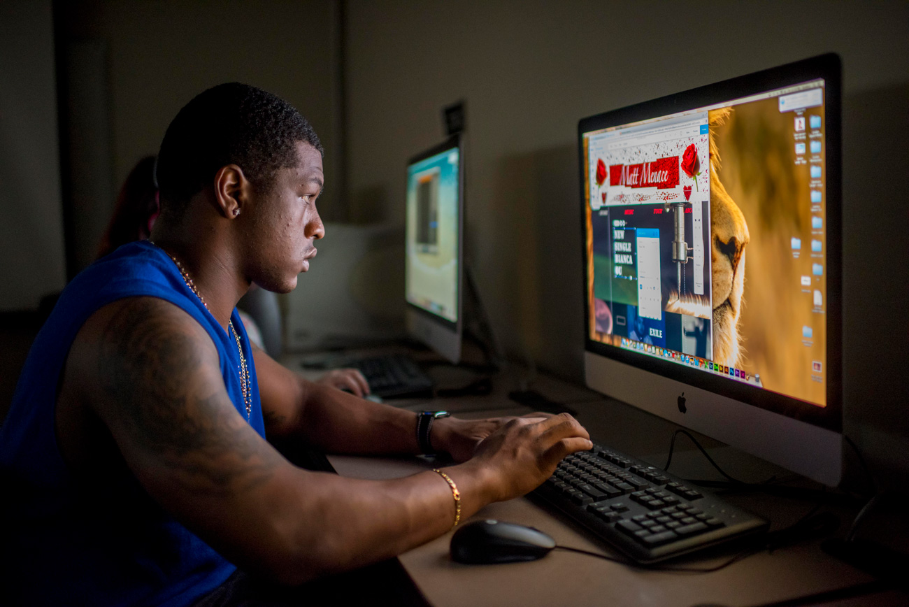 Male student editing images on computer