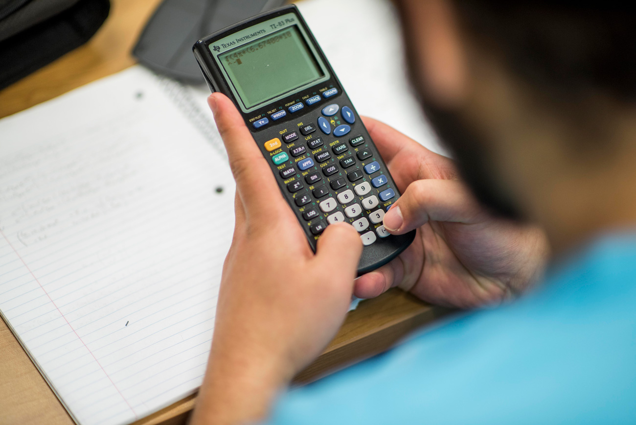 Male student using his calculator during class