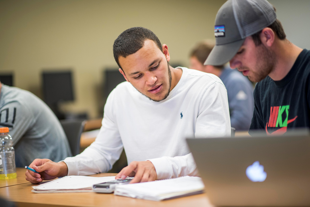 Two male students working on together in mathematics class