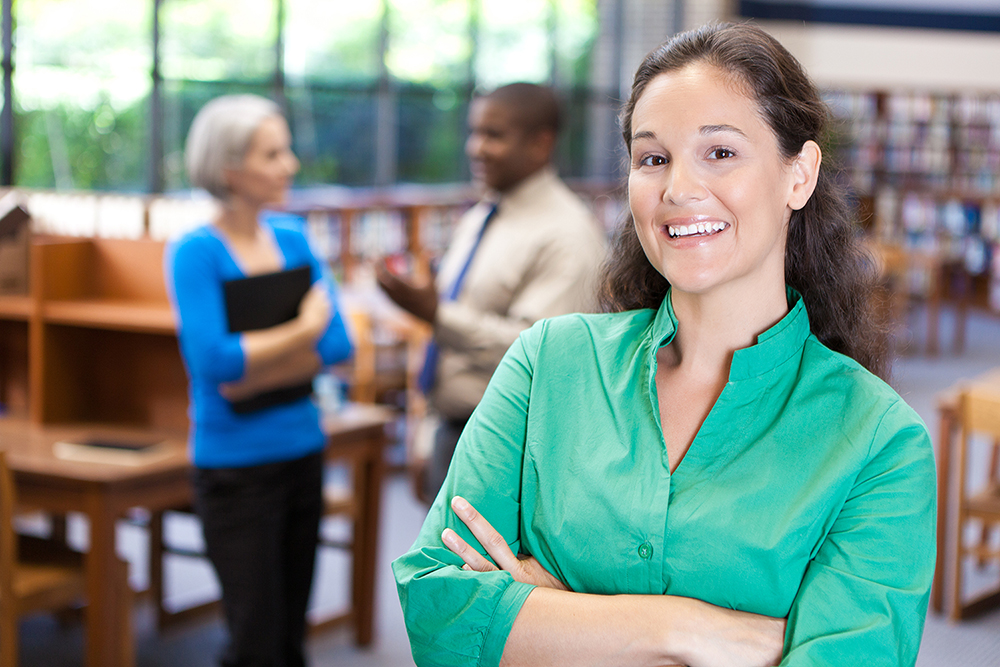 Confident business woman smiles with team of professional colleagues behind her