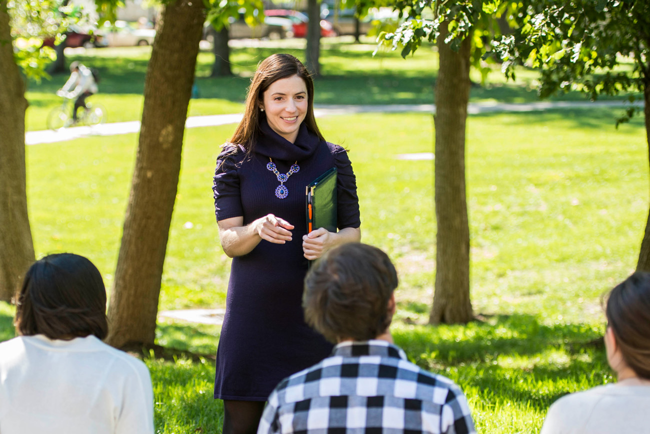 An outdoor class led by Dr. Kimberly Schaefer, Assistant Professor of Communication Studies, with students listening