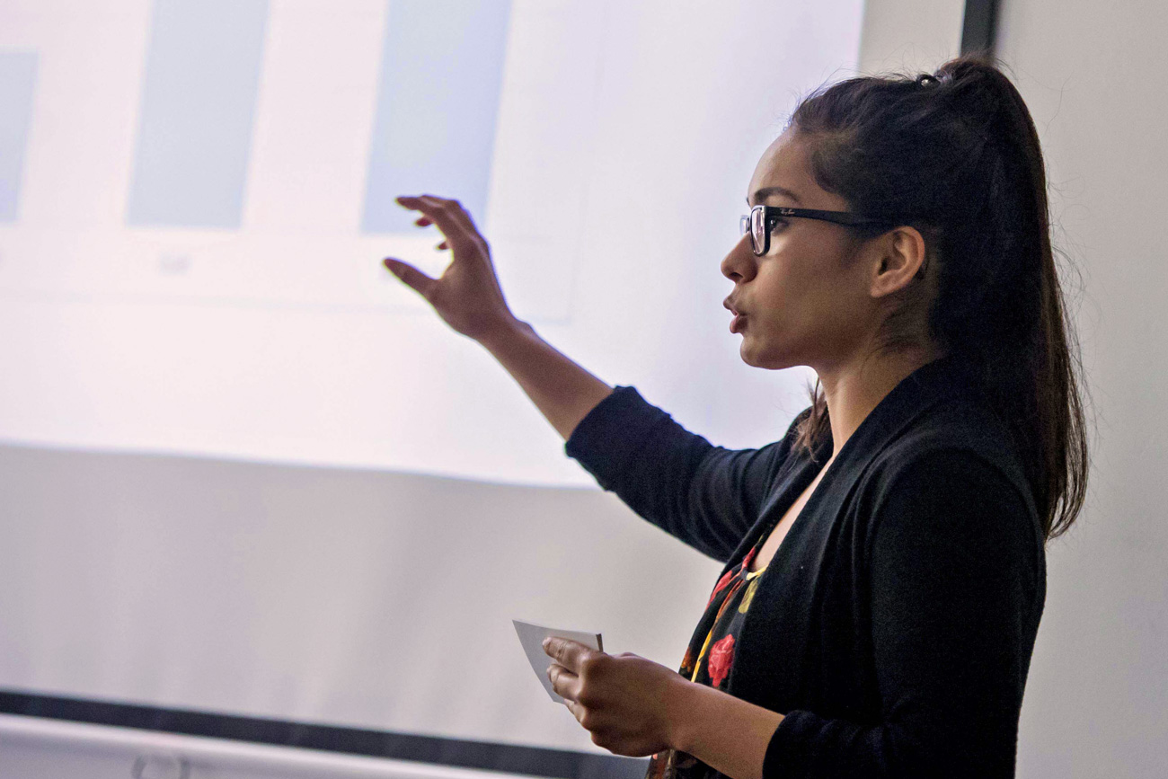 Female student giving a presentation with notecards in hand