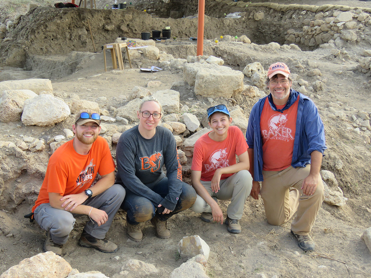 Religious studies students kneeling in the dirt during an excavation dig in Israel with Professor Nicholaus Pumphrey