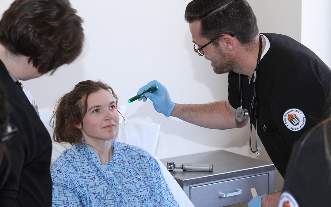 Nursing student testing eyes of a volunteer patient