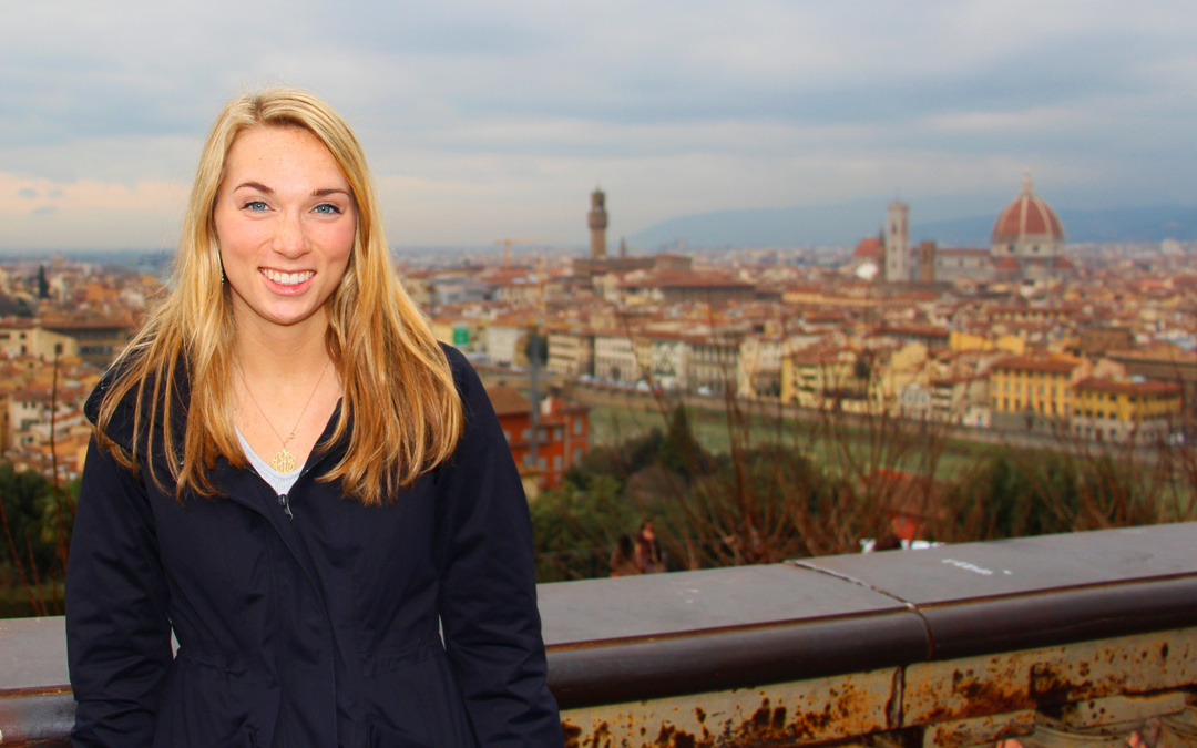 Baker student stands in front of panorama of Florence, Italy.
