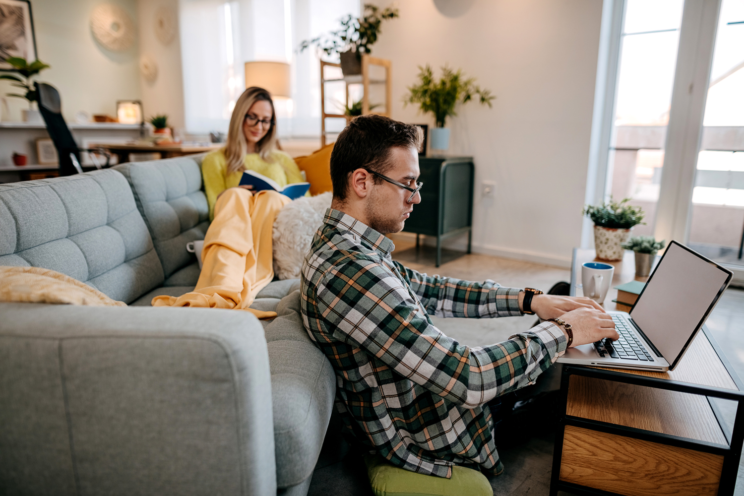 man working on a laptop and woman reading a book