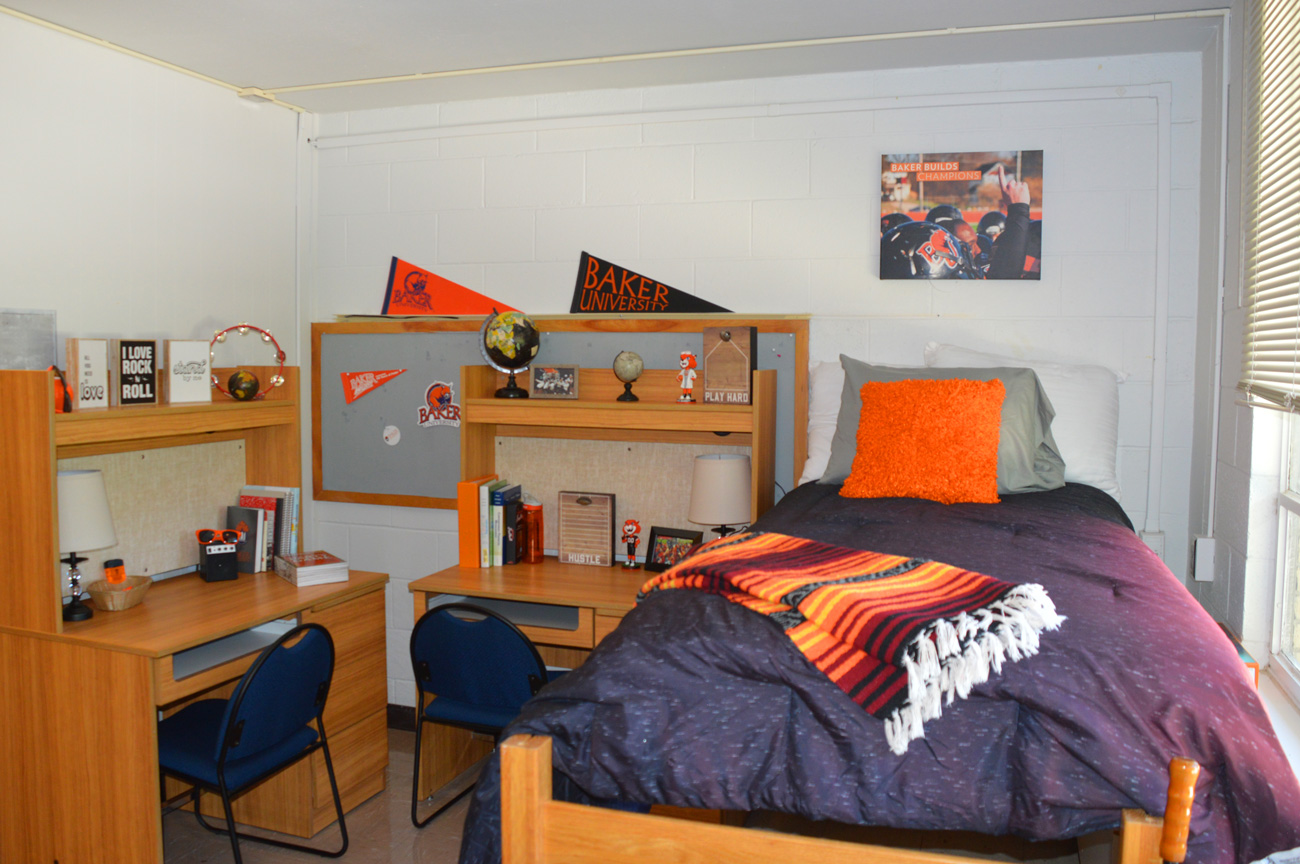 A decorated bed and two desks to the left within Irwin and Gessner Hall