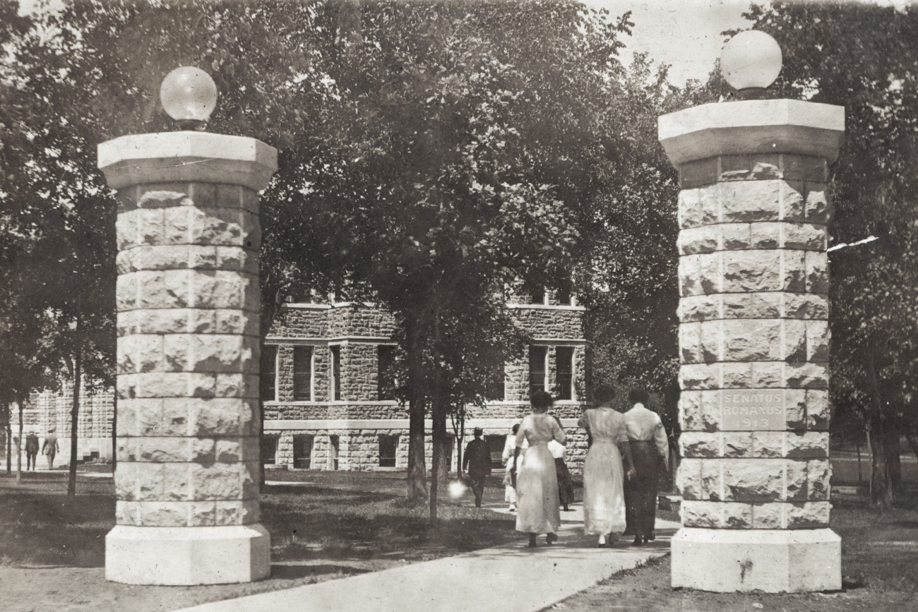 Black and white photo of students walking on campus in the early 1900s by Case Hall