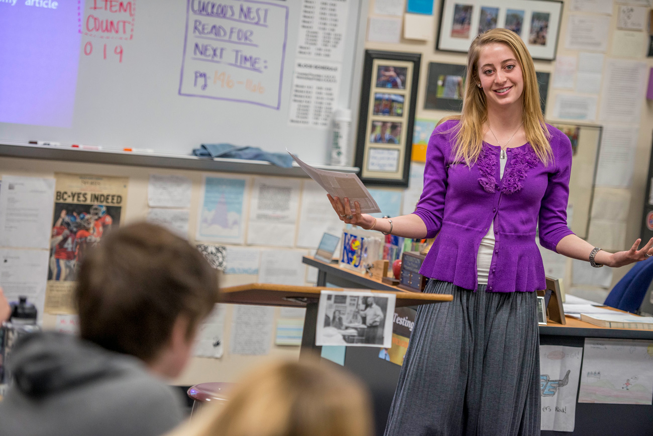 High school teacher standing at the front of classroom teaching a lesson