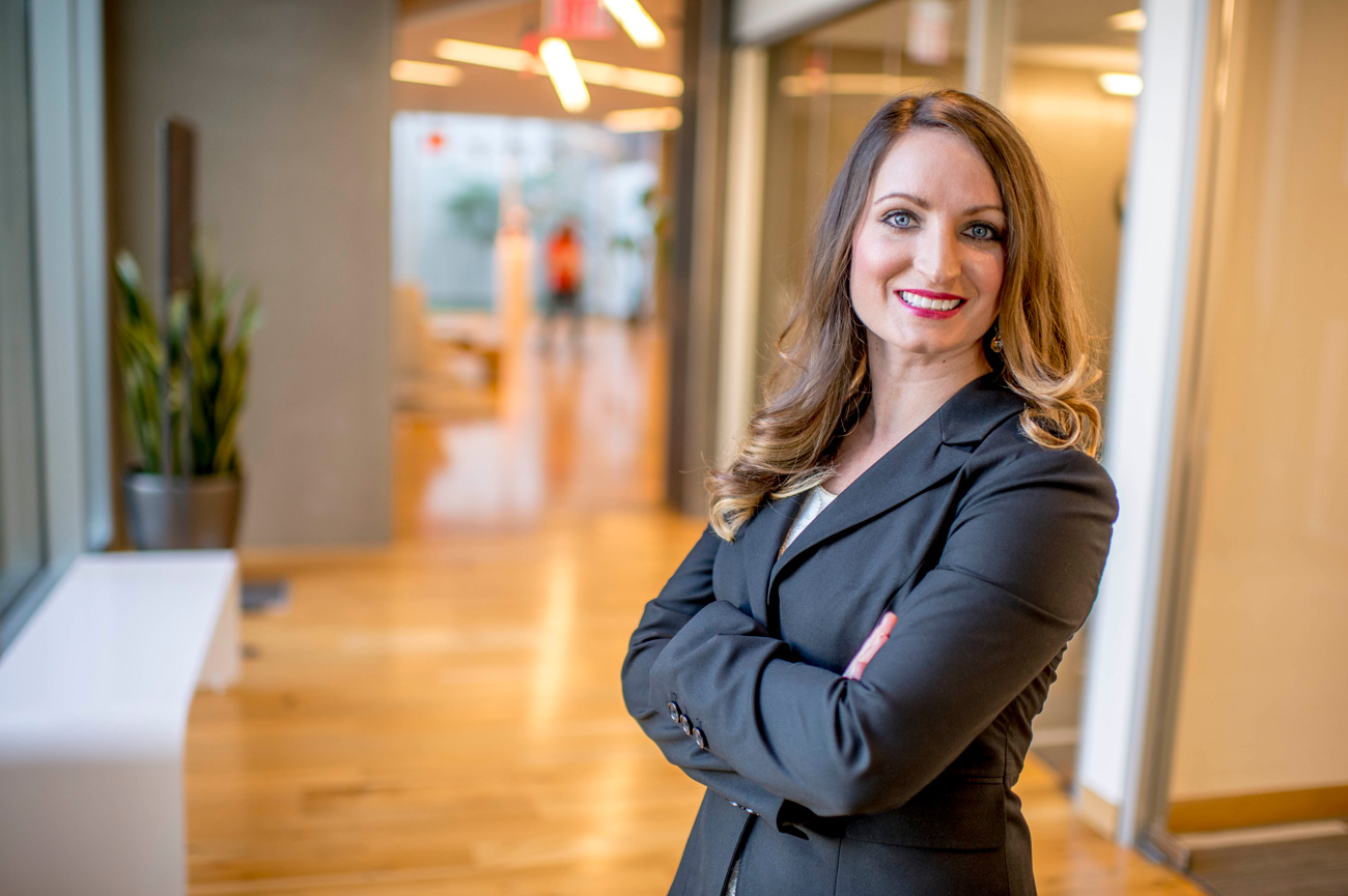 professional business woman smiling and posing with crossed arms for photo
