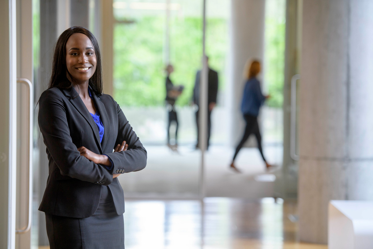 professional business woman smiling and posing with crossed arms for photo